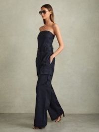 REISS Lois Strapless Belted Wide Leg Jumpsuit in Navy – chic dark blue bandeau neckline cargo style jumpsuits – utility inspired occasion clothing