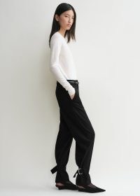 TOTEME Buckled slouch trousers in black ~ women’s chic slouchy buckle detail ankle tie trouser