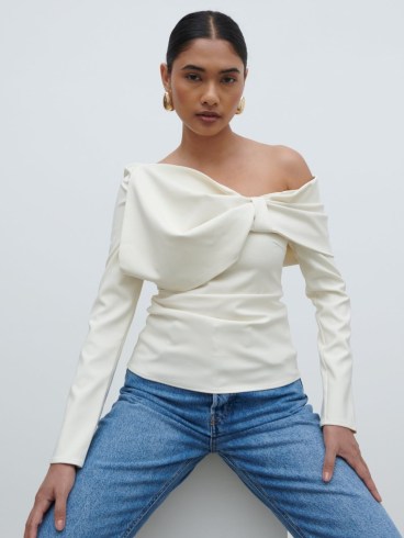 PRETTY LAVISH Naomi Exaggerated Bow Top in Cream | chic long sleeve one shoulder tops | asymmetric fashion